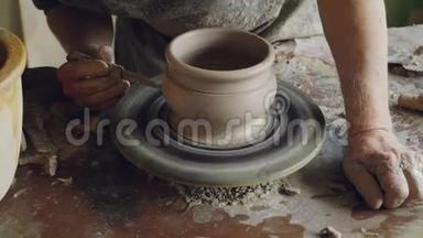男用手在旋转<strong>锅具</strong>上用刀装饰陶瓷锅，`抛盘，做装饰品